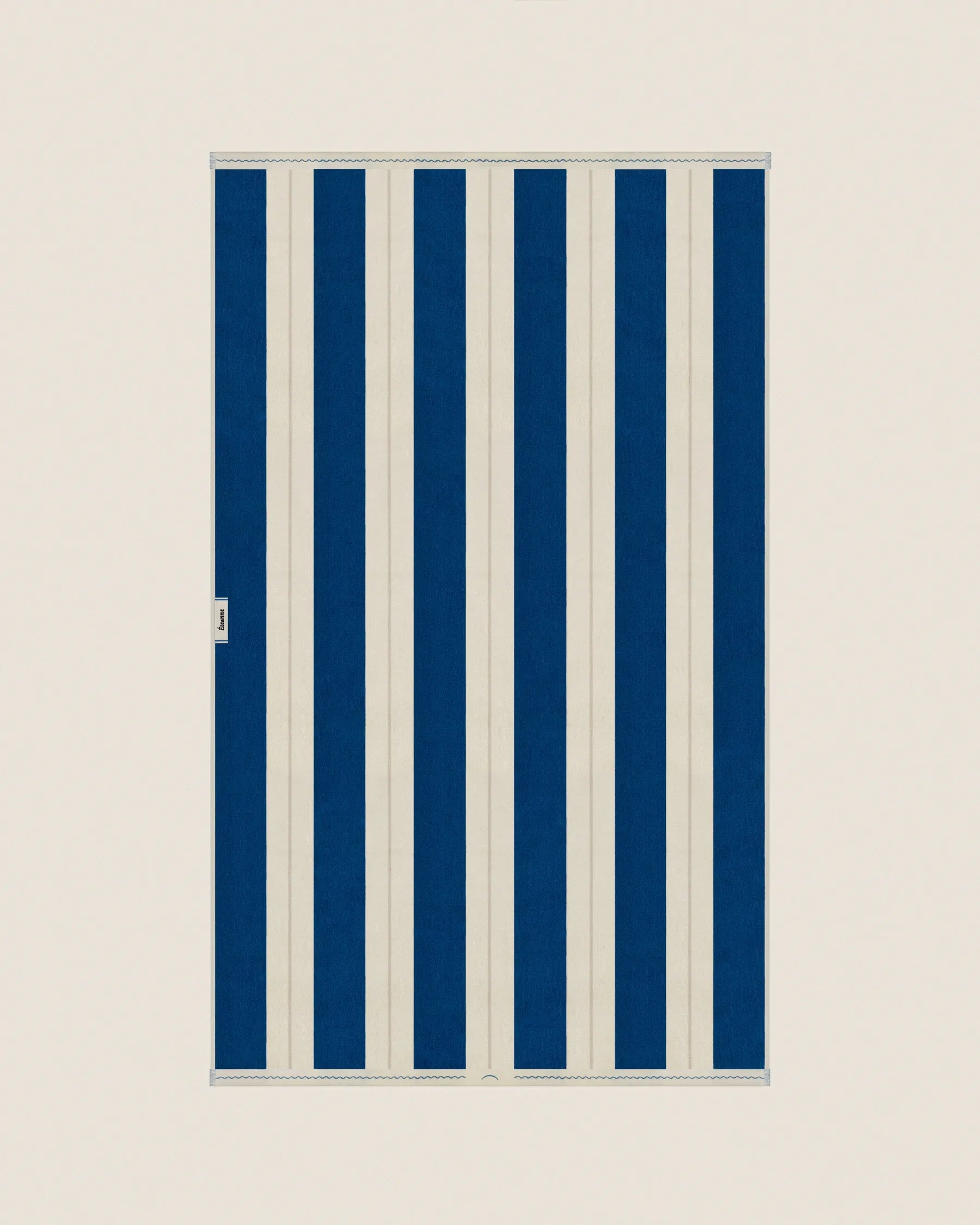 Folded striped Éteanne beach towel tuscan sun and ivory tones showing thickness and softness