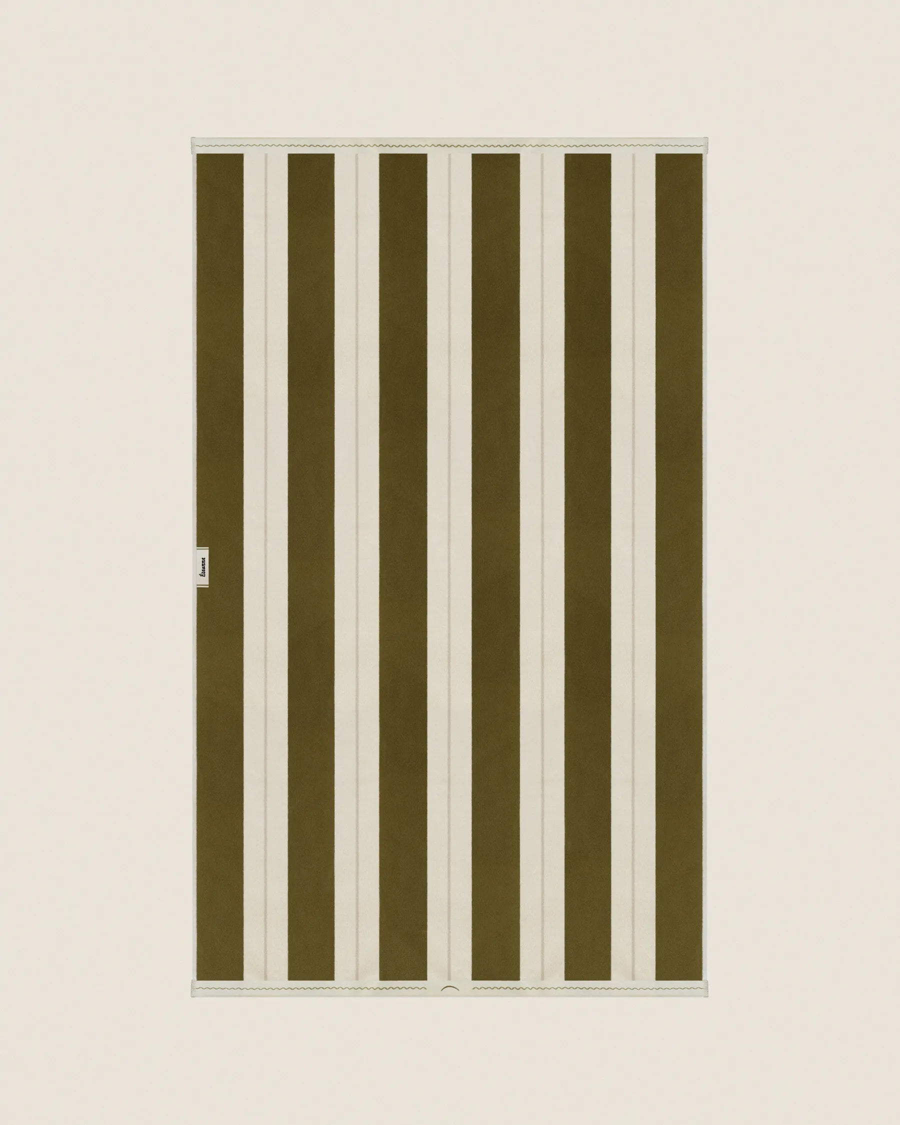 Striped beach towel in Terre Verte and Ioanian Pearl, laid flat on a neutral background