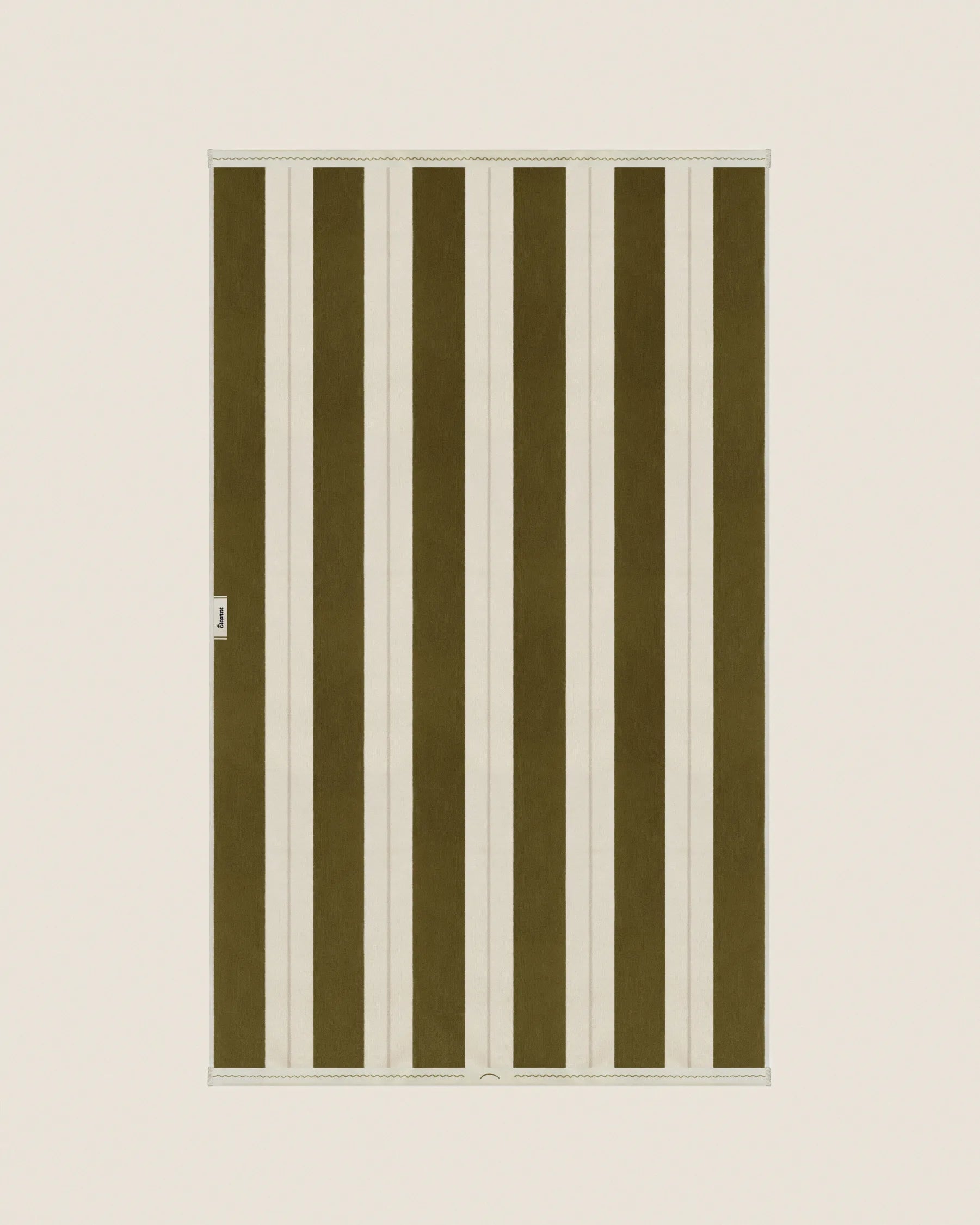 Striped beach towel in Terre Verte and Ioanian Pearl, laid flat on a neutral background