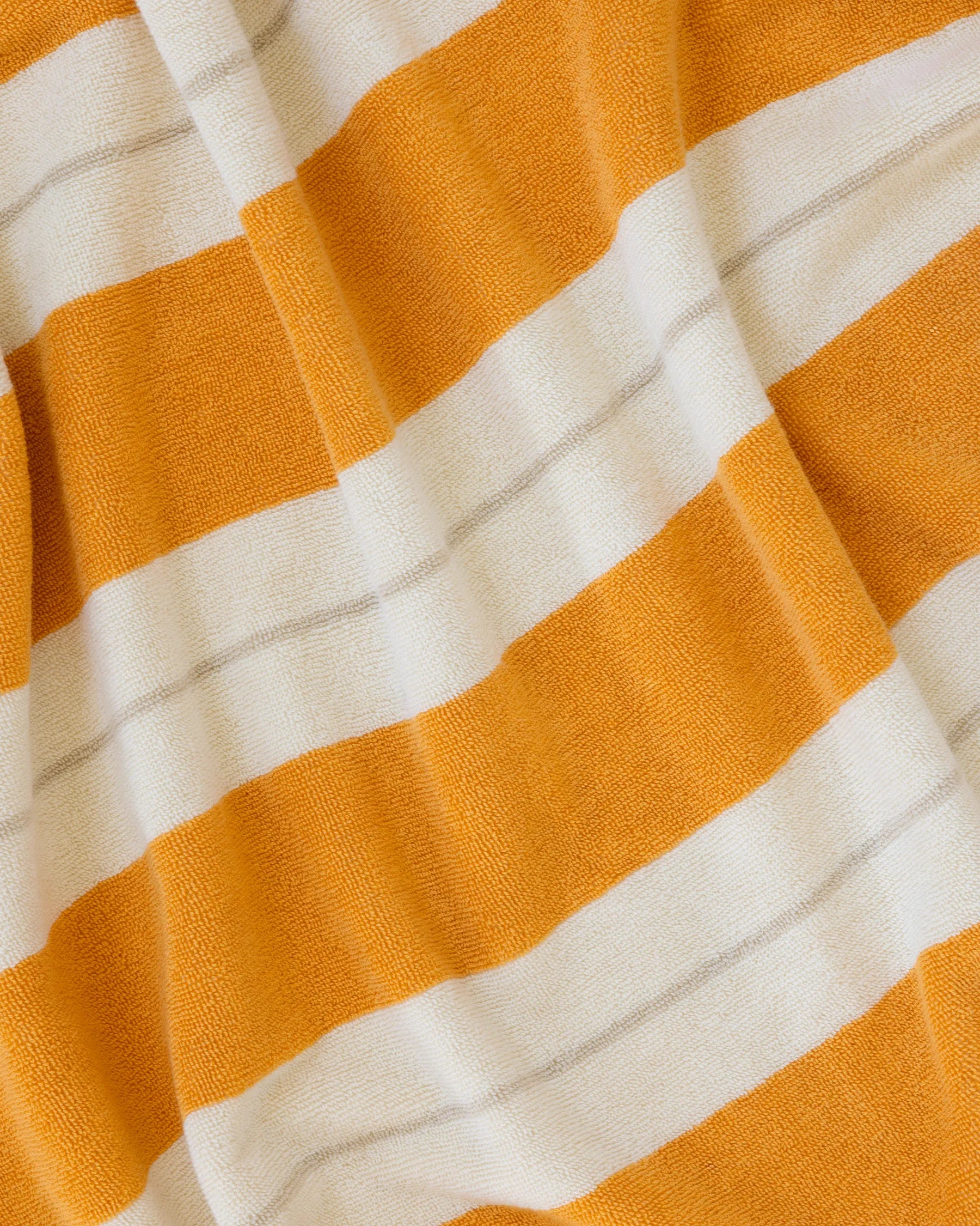 Éteanne beach cotton towel draped in natural folds highlighting texture and absorbency
