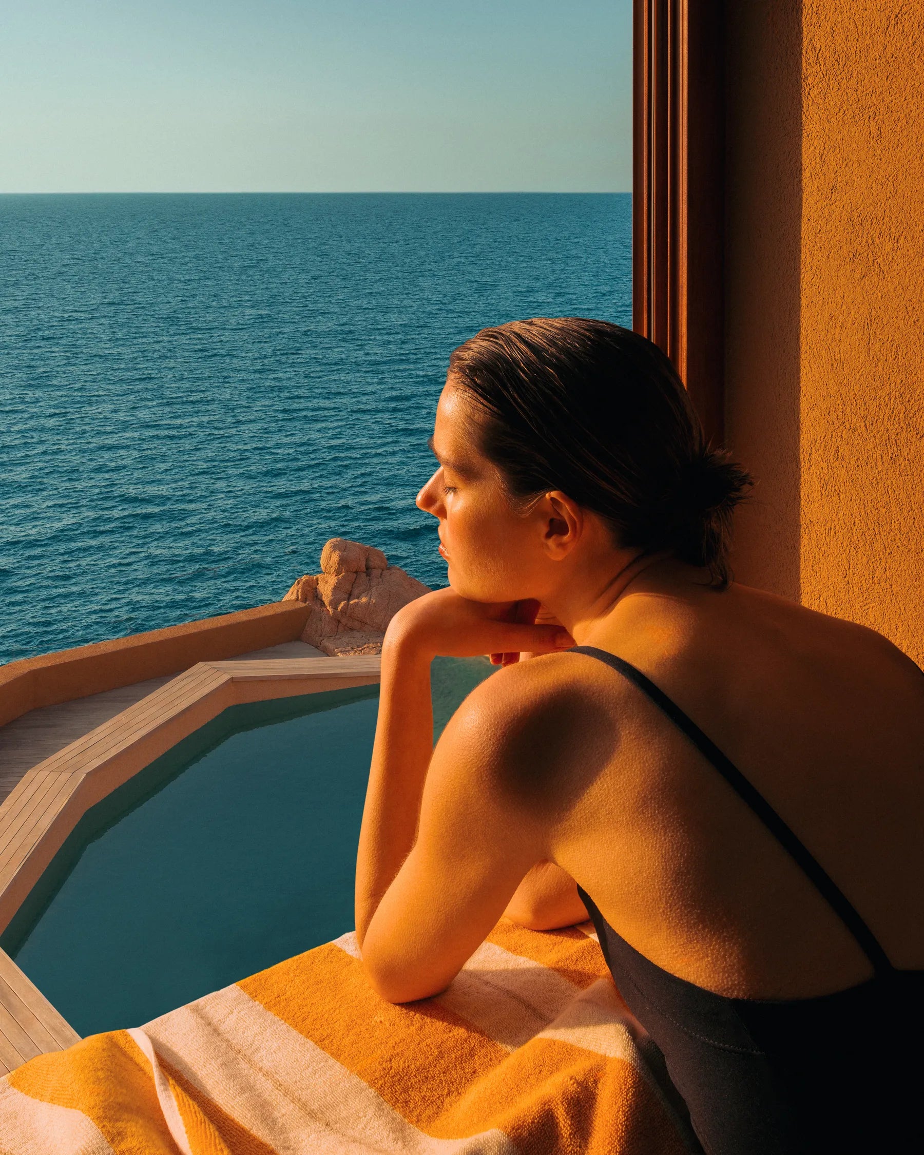 Mediterranean coastal pool overlooking rocky shoreline at sunset