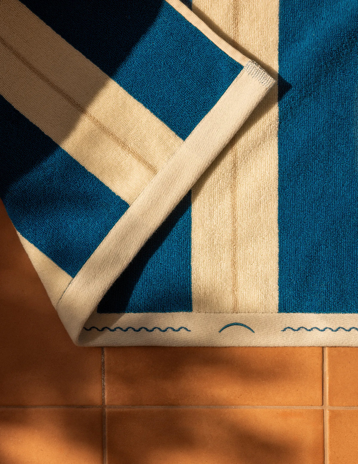Éteanne beach cotton towel draped in natural folds highlighting texture and absorbency