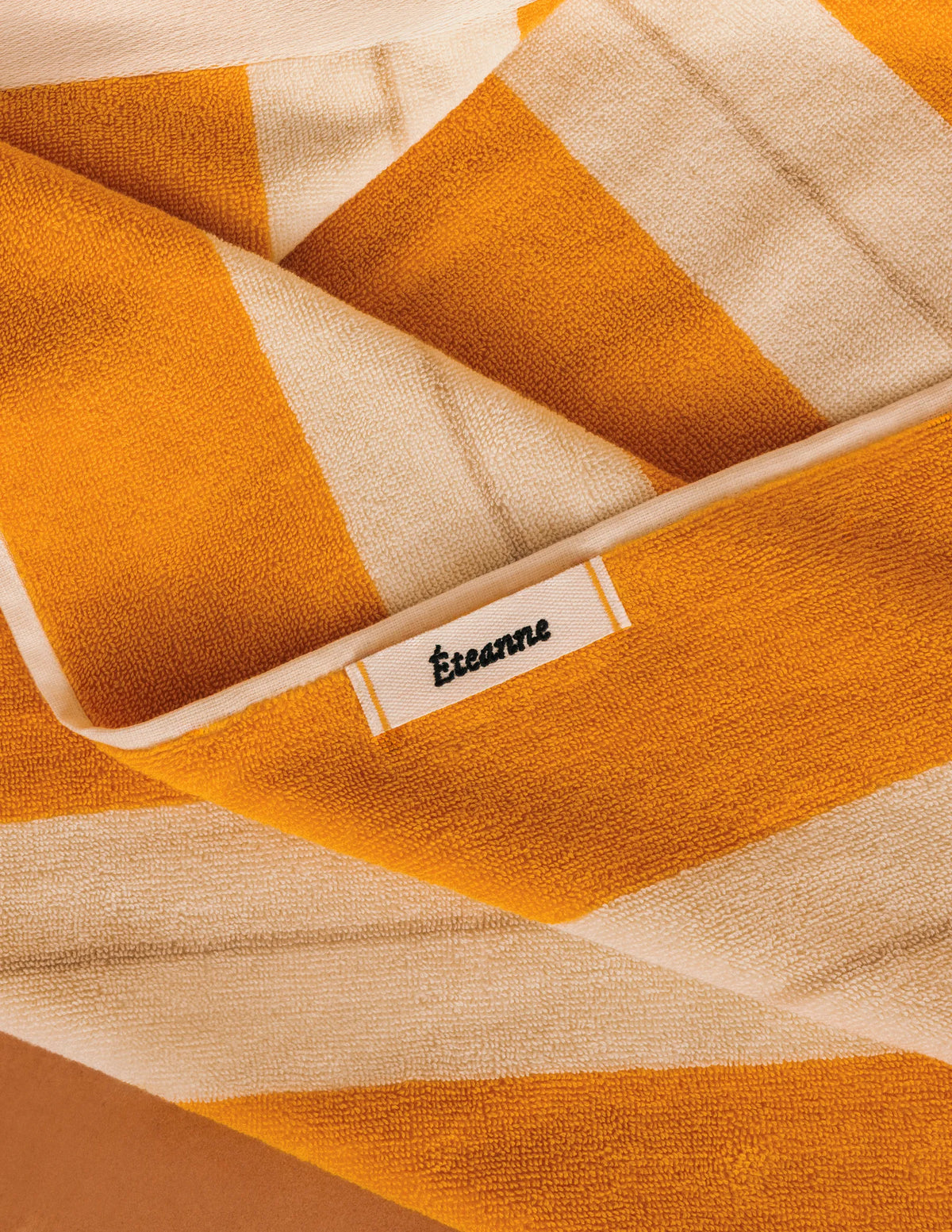 Éteanne beach cotton towel draped in natural folds highlighting texture and absorbency