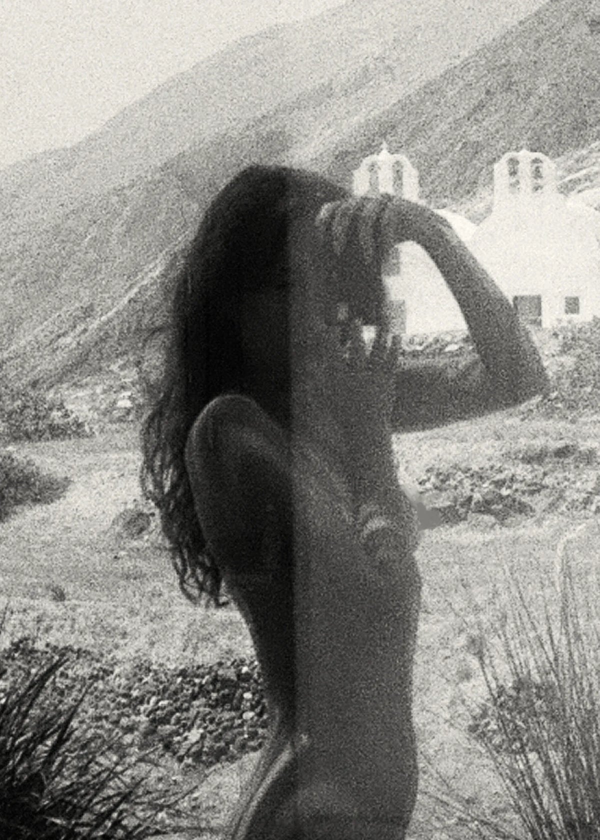 Alexandria Coe photographing a whitewashed church in the Mediterranean landscape