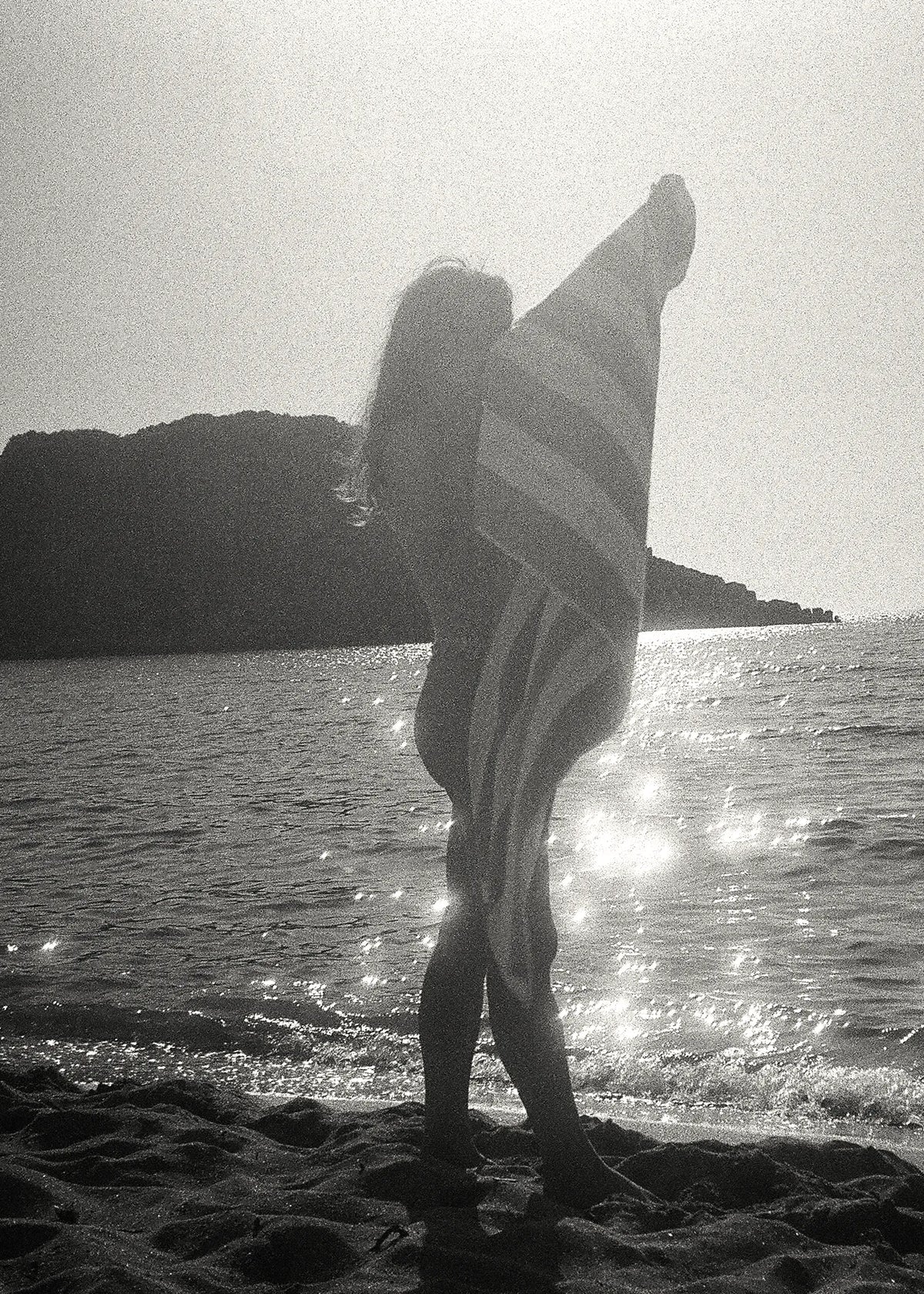 Alexandria Coe wrapped in a striped beach towel by the Mediterranean Sea