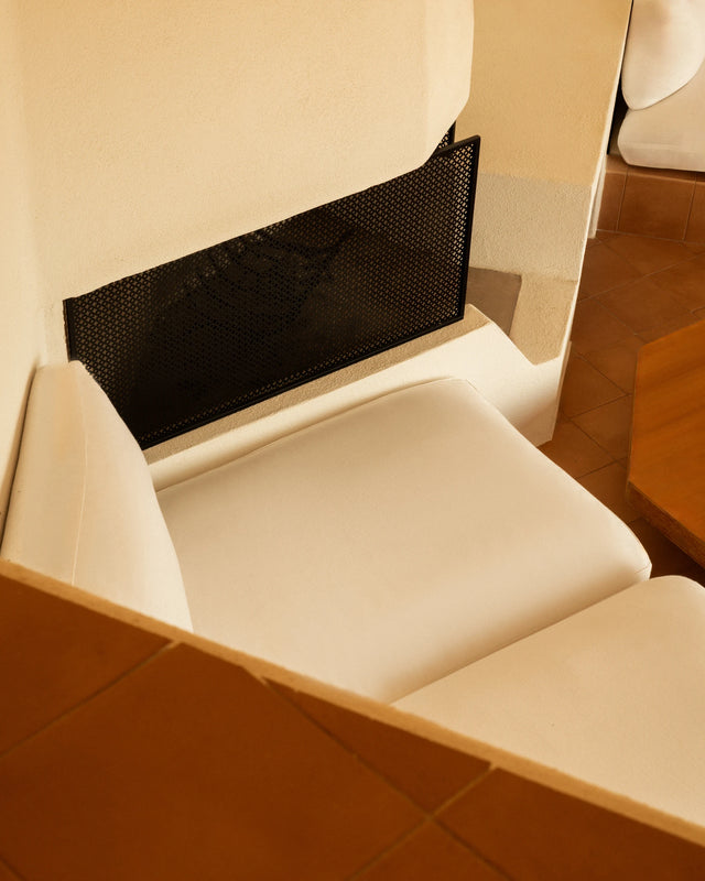 Built-in fireplace and white plaster seating inside Casa Scalesciani.