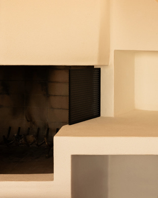 Built-in fireplace and white plaster seating inside Casa Scalesciani.