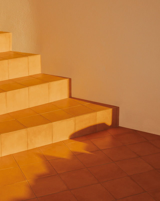 Sunlight illuminating terracotta steps inside Casa Scalesciani in Sardinia.