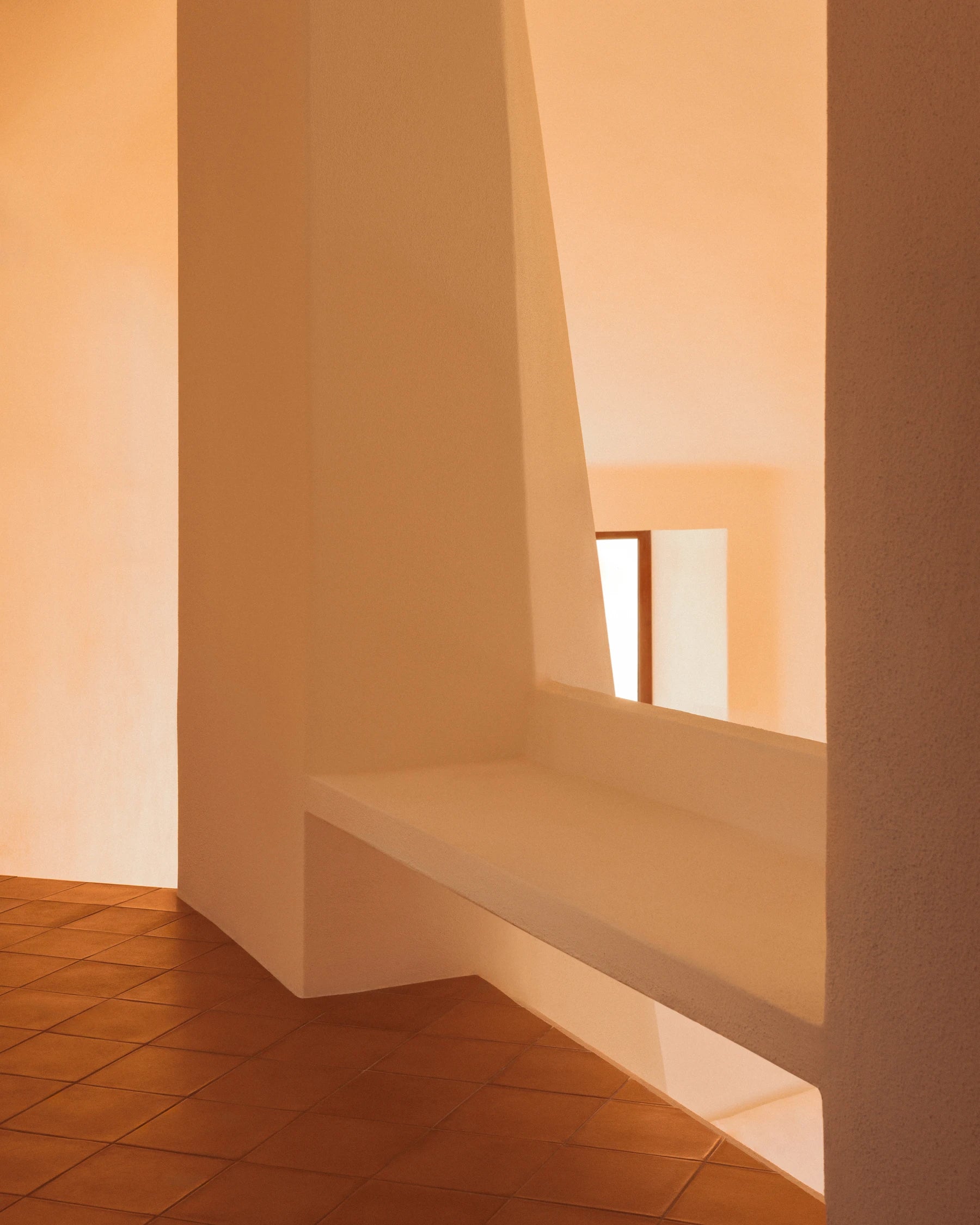 Sunlit white plaster interior with terracotta floor at Casa Scalesciani.