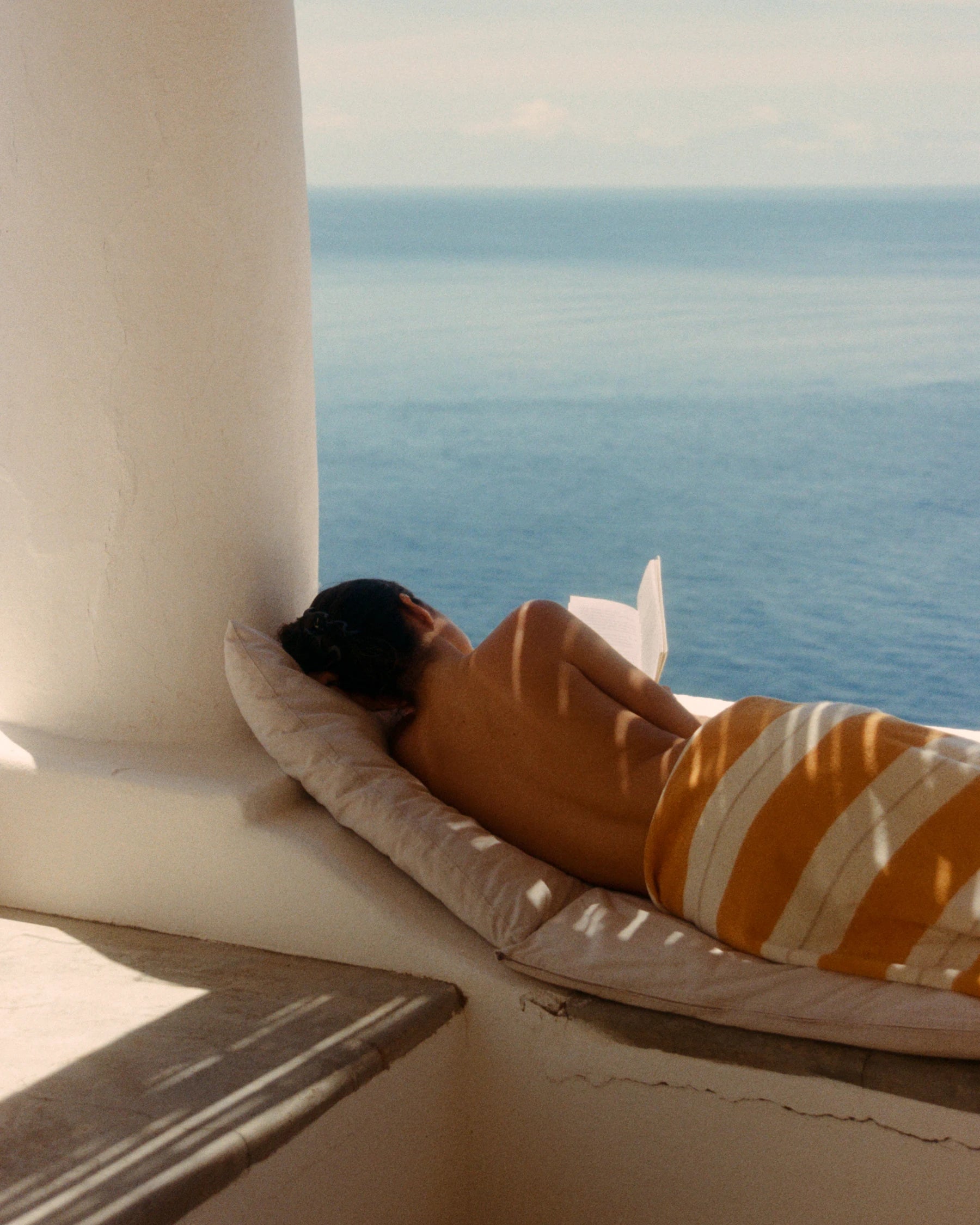 Woman resting on the Anne Beach Towel overlooking the Mediterranean Sea.