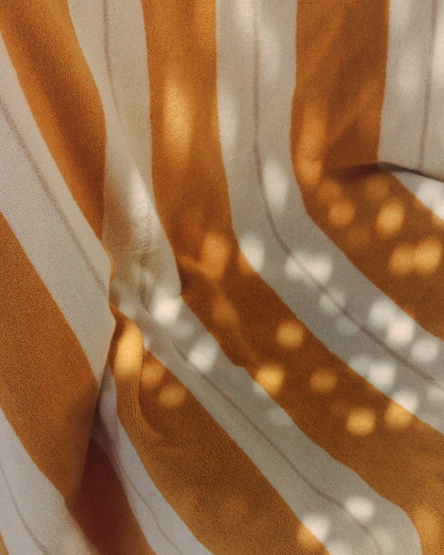 Close-up of the Anne Beach Towel in Tuscan Sun illuminated by Mediterranean sunlight.