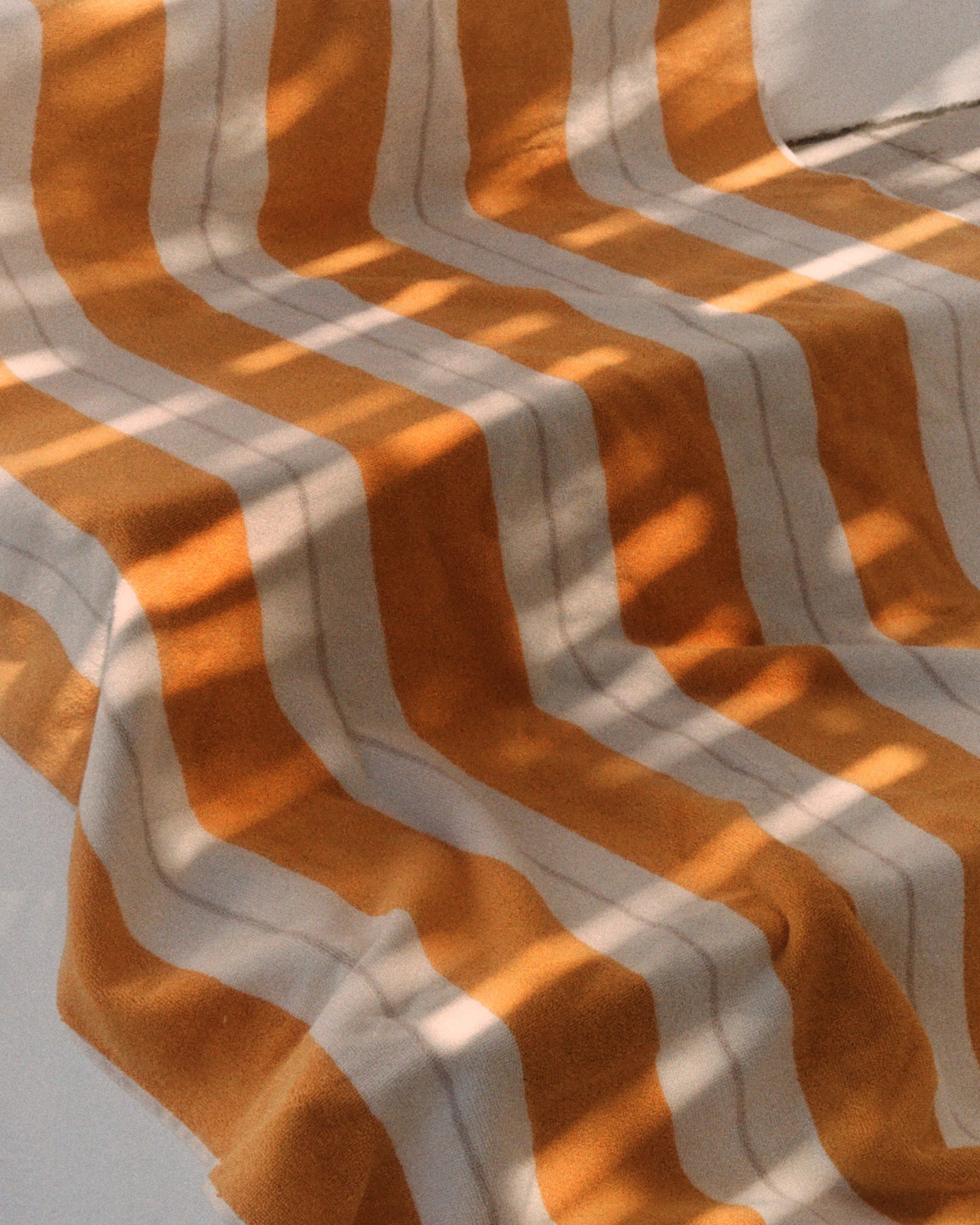 Close-up of the Anne Beach Towel in Tuscan Sun illuminated by Mediterranean sunlight.