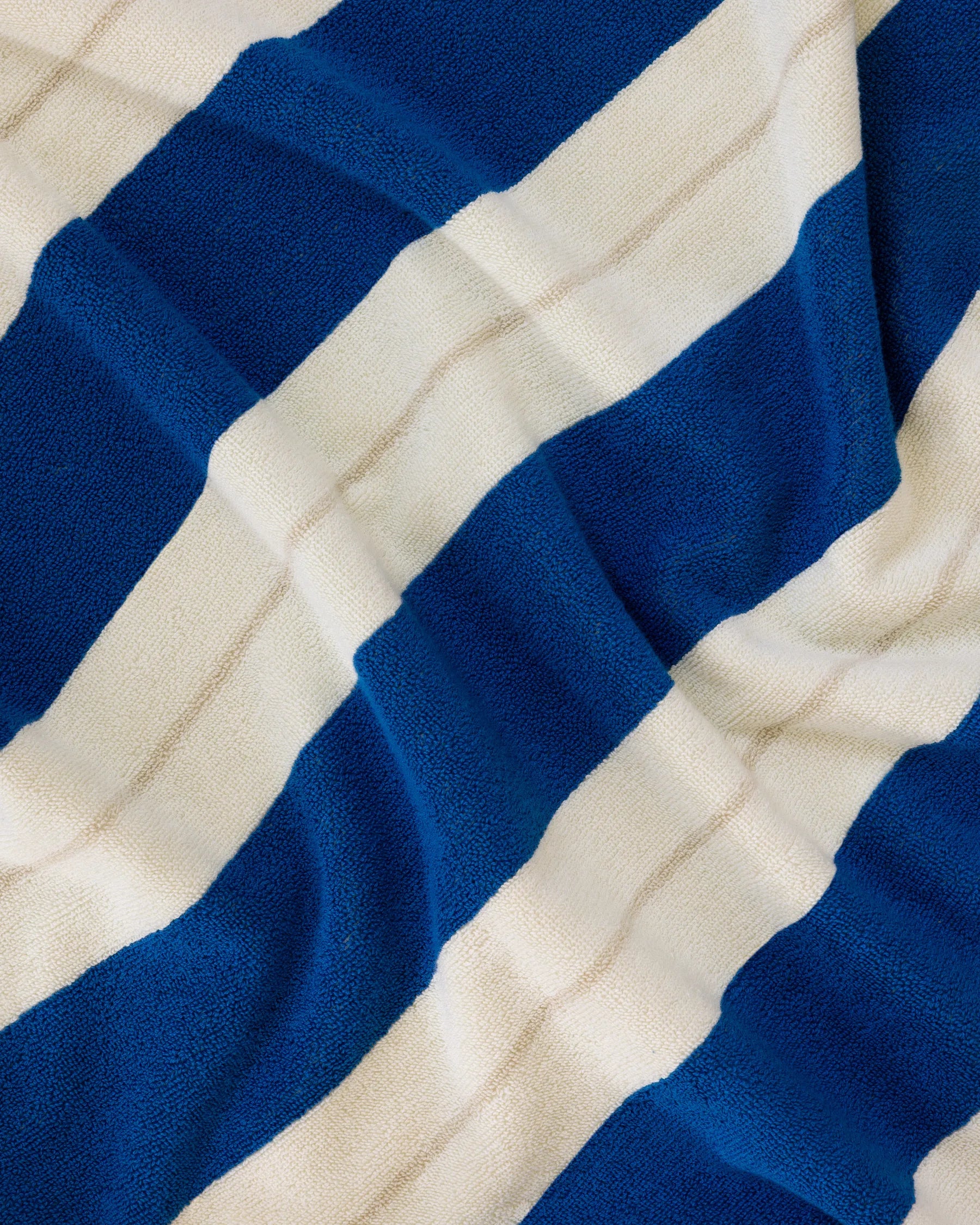 Éteanne beach cotton towel draped in natural folds highlighting texture and absorbency