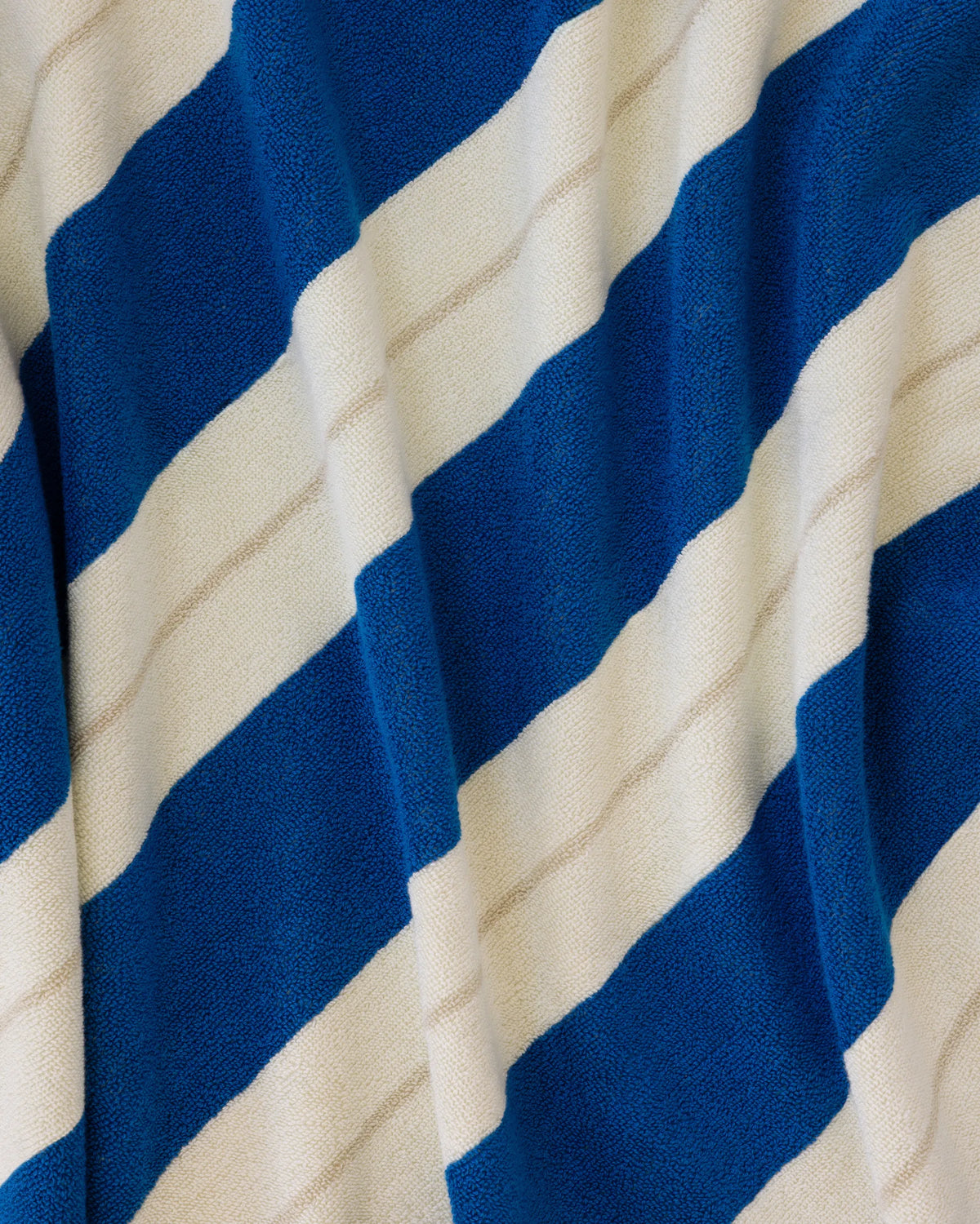 Éteanne beach cotton towel draped in natural folds highlighting texture and absorbency