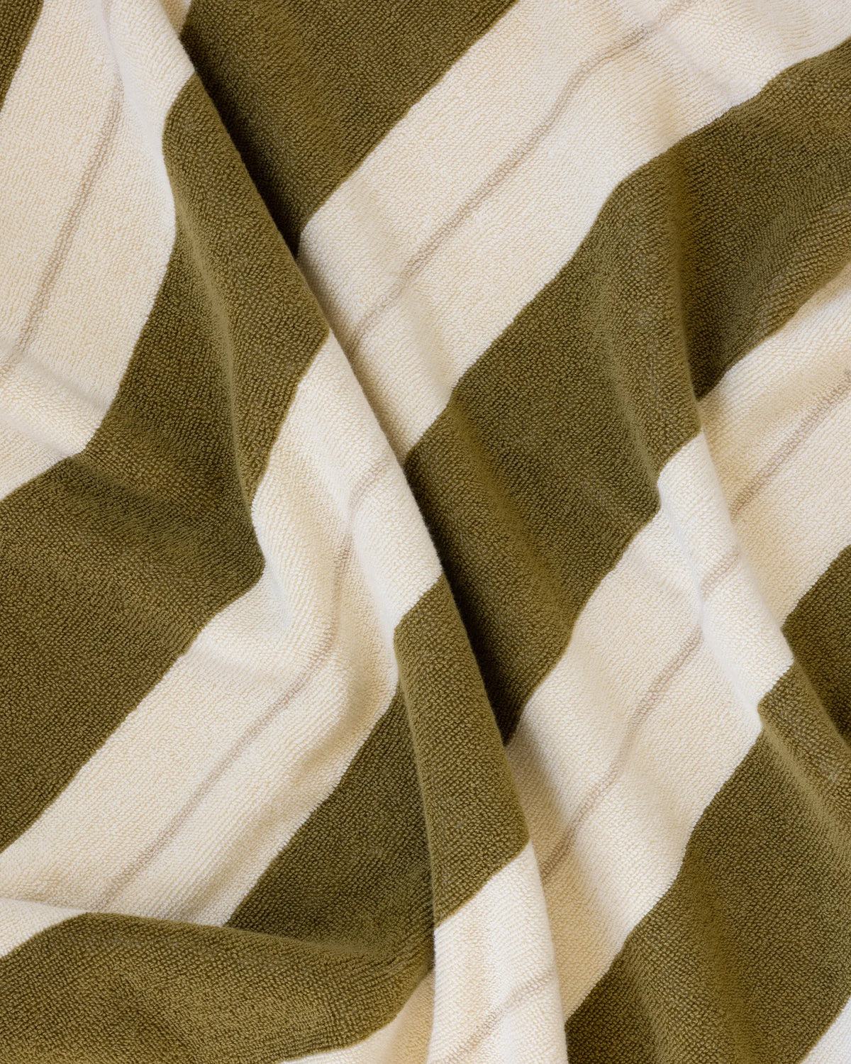 Éteanne beach cotton towel draped in natural folds highlighting texture and absorbency