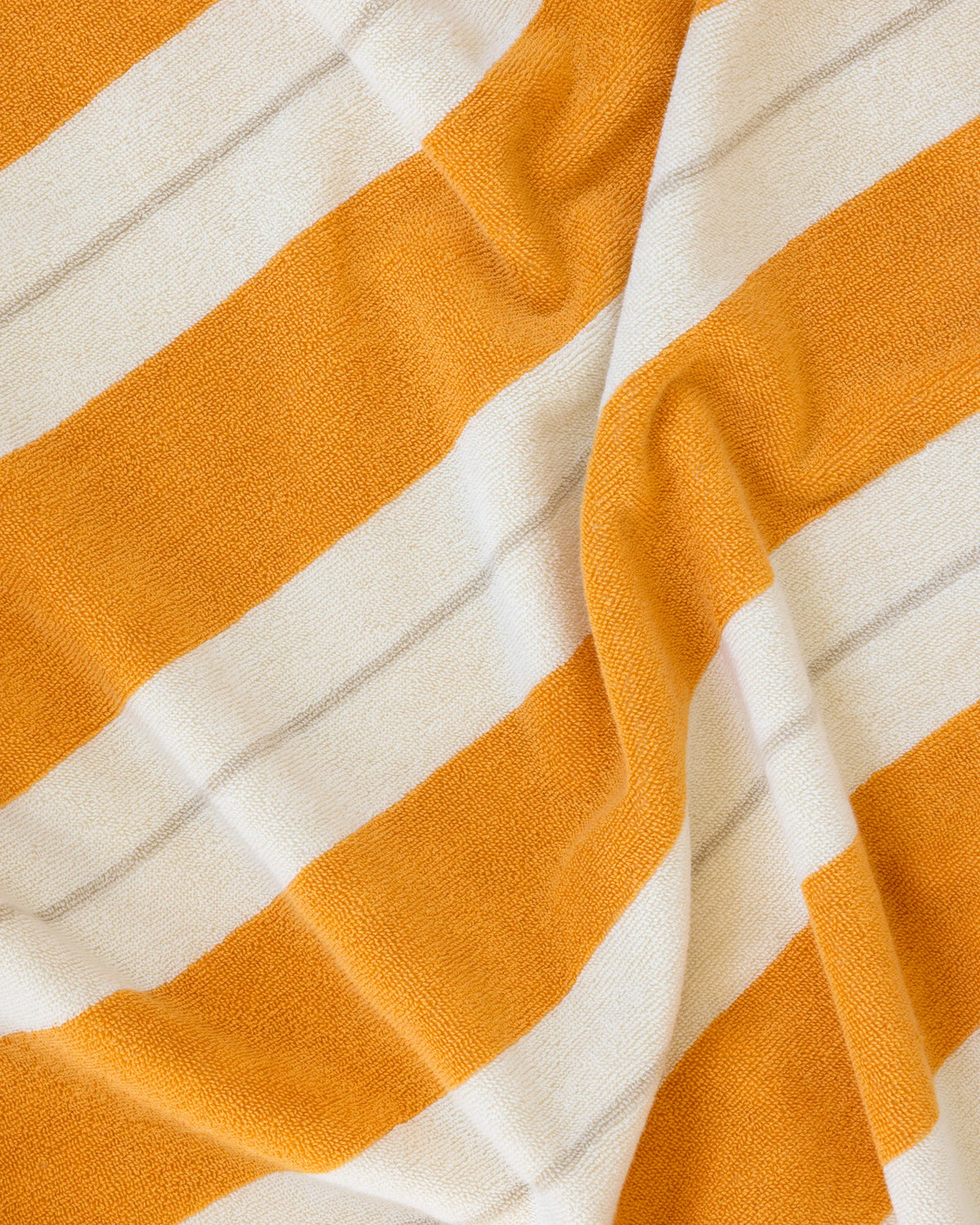 Éteanne beach cotton towel draped in natural folds highlighting texture and absorbency