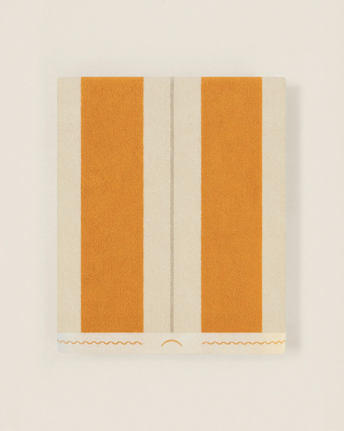 Folded striped beach towel tuscan sun in orange and ivory tones showing thickness and softness
