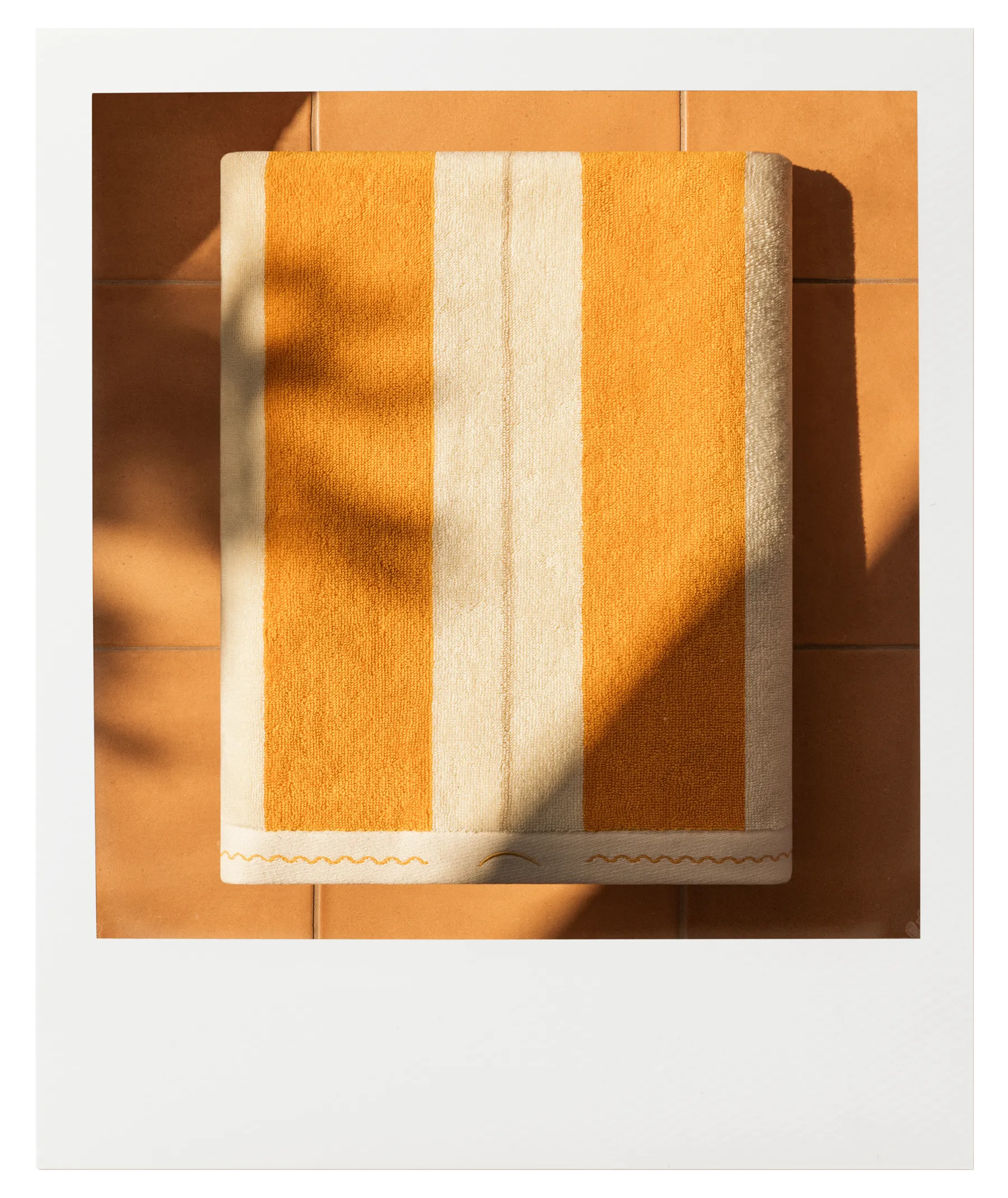 Éteanne Anné striped towel in Tuscan SUn, warm yellow and sand tones on sunlit terracotta tiles