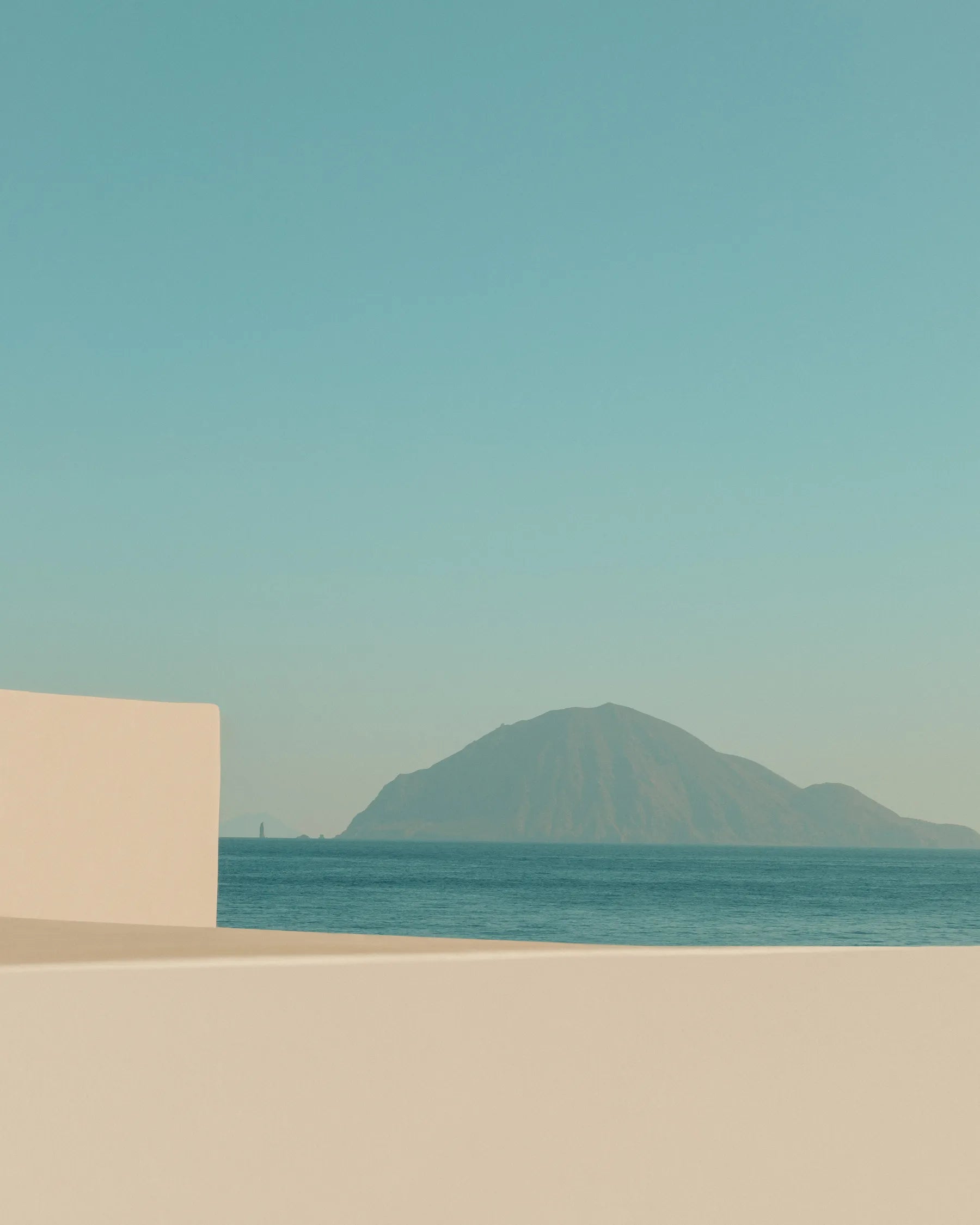 Minimal Mediterranean architecture with sea view and island under clear blue sky