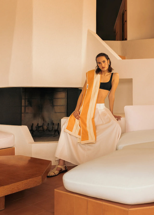 Woman wearing Éteanne Anné beach towel in Tuscan Sun in sunlit interior