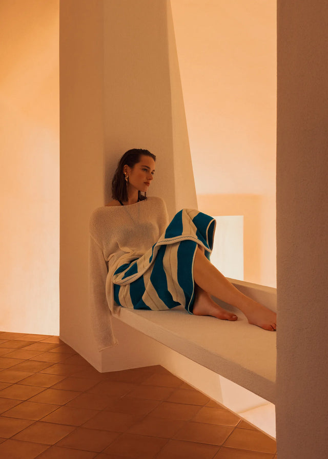 Woman wearing Éteanne Anné striped towel in Azure seated in Mediterranean interior