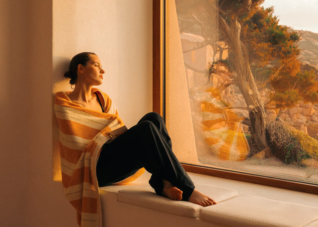Woman in Éteanne striped beach towel in Tuscan Sun by Mediterranean window