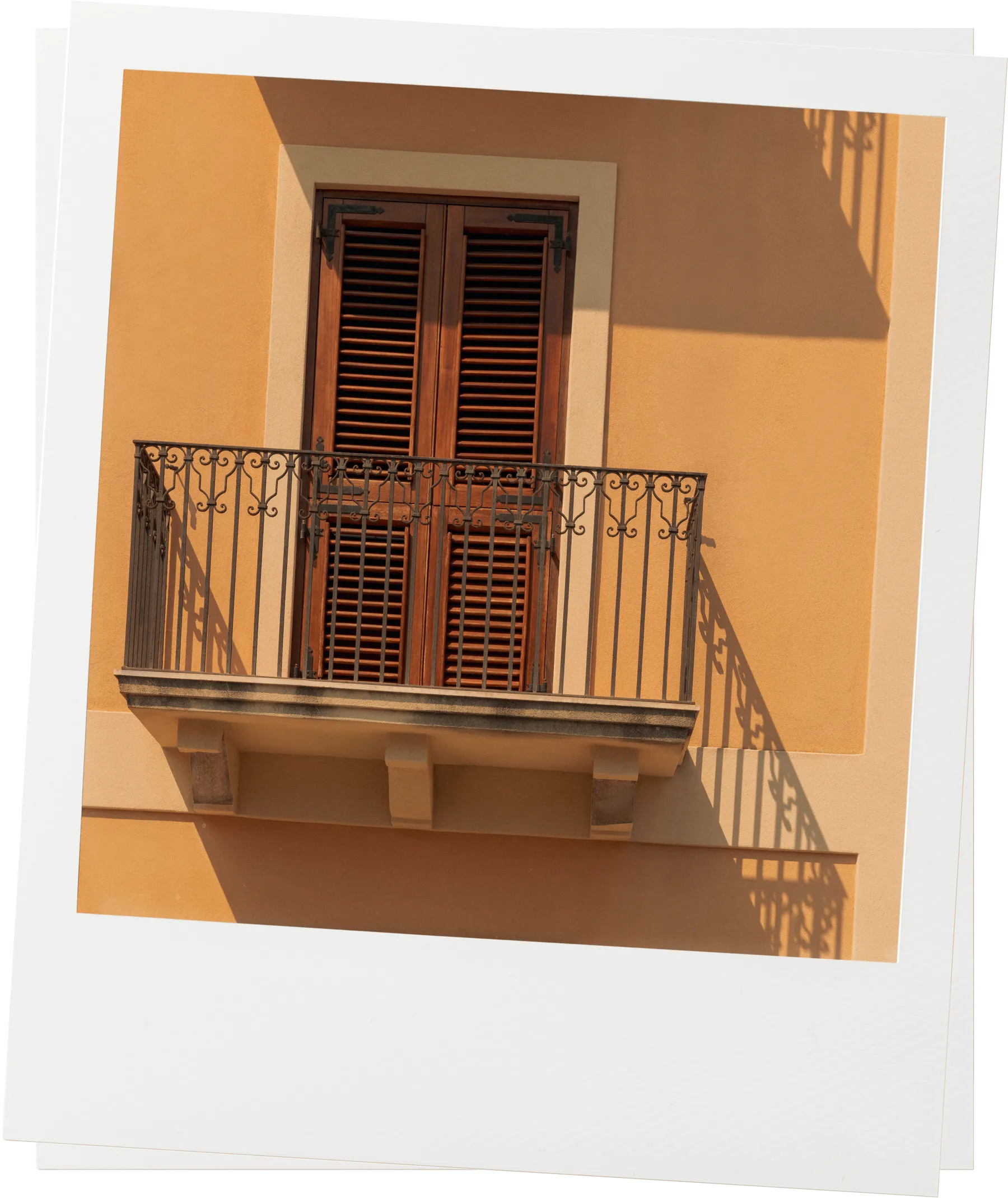Sunlit Mediterranean balcony with wooden shutters and iron railing